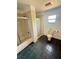 Bathroom featuring tiled flooring, a dual shower and tub, and a toilet next to a window at 439 Corbett Rd, Lithia, FL 33547