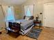 Bedroom with wood flooring, light walls, two windows with blinds and curtains, plus a wooden bench at 439 Corbett Rd, Lithia, FL 33547