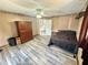 Bedroom with neutral walls, wood-look flooring, ceiling fan, and large wood cabinet at 439 Corbett Rd, Lithia, FL 33547
