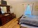 Bedroom with wood floors, a light blue comforter, a dark wooden dresser, and curtains at 439 Corbett Rd, Lithia, FL 33547