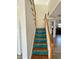 A staircase with light wood steps and turquoise risers leads to an open-concept room at 439 Corbett Rd, Lithia, FL 33547