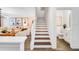 Bright entryway featuring stairs, a powder room, and an open floor plan leading to the living room with a comfortable sofa at 4511 S Manhattan Ave # 11, Tampa, FL 33611