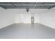 This garage is a spacious two car with white walls and grey concrete flooring at 4511 S Manhattan Ave # 11, Tampa, FL 33611
