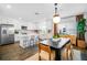 Open kitchen and dining area with modern white cabinets and stainless steel appliances at 4511 S Manhattan Ave # 11, Tampa, FL 33611