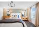 Serene main bedroom with neutral tones, dual nightstands, decorative mirrors, a modern chandelier, and plenty of natural light at 4511 S Manhattan Ave # 11, Tampa, FL 33611