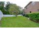 A spacious backyard with lush green grass, a privacy fence, neatly trimmed hedges, and an enclosed lanai at 4750 Augusta Ave, Oldsmar, FL 34677