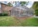 Backyard view of the home featuring a screened in pool, spa, lush landscaping, and a partial privacy fence at 4750 Augusta Ave, Oldsmar, FL 34677