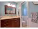 Bathroom vanity with a single sink and dark wood cabinets, adjacent to a separate toilet room at 4750 Augusta Ave, Oldsmar, FL 34677