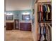 View of a well-organized walk-in closet into a stylish bathroom with dual vanities at 4750 Augusta Ave, Oldsmar, FL 34677