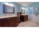 Bathroom featuring double sinks with dark wood cabinets and light countertops with a separate toilet room at 4750 Augusta Ave, Oldsmar, FL 34677