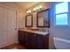 Bathroom featuring dual vanity, granite counters, wood cabinets, framed mirrors and hardwood floors at 4750 Augusta Ave, Oldsmar, FL 34677
