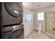 Modern bathroom featuring a stackable washer and dryer, a walk-in shower, and built-in storage at 4750 Augusta Ave, Oldsmar, FL 34677