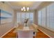 Bright dining room features a modern chandelier, a large window with plantation shutters, and a table set for a cozy meal at 4750 Augusta Ave, Oldsmar, FL 34677