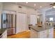 Bright kitchen boasts granite counters, stainless steel refrigerator, wood floors and white cabinets at 4750 Augusta Ave, Oldsmar, FL 34677