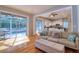 Open living room with wood floors, sliders to screened lanai and access to the kitchen at 4750 Augusta Ave, Oldsmar, FL 34677