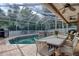 Enclosed pool area with pavers, poolside dining area, grill, spa, and direct access to the home at 4750 Augusta Ave, Oldsmar, FL 34677