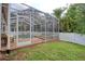 A screened-in pool and spa featuring brick flooring, patio furniture, and a lush green yard at 4750 Augusta Ave, Oldsmar, FL 34677