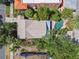 Aerial view of the home featuring a backyard pool, lush landscaping, and a neutral toned roof at 506 S Melville Ave, Tampa, FL 33606