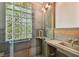 Modern bathroom featuring glass-blocked window and stone sink at 506 S Melville Ave, Tampa, FL 33606