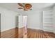 Bright bedroom featuring wood floors, built-in shelving, and unique fan at 506 S Melville Ave, Tampa, FL 33606