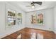 Sunny bedroom featuring hardwood floors, ceiling fan, and large windows offering exterior views at 506 S Melville Ave, Tampa, FL 33606