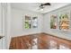 Bright bedroom featuring hardwood floors, classic trim, and large windows overlooking lush greenery at 506 S Melville Ave, Tampa, FL 33606