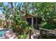 Exterior view of screened-in porch surrounded by beautiful, lush, tropical landscaping at 506 S Melville Ave, Tampa, FL 33606