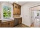 Cozy kitchen features a farmhouse sink, wooden cabinets, and stainless steel dishwasher at 506 S Melville Ave, Tampa, FL 33606