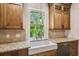 Cozy kitchen featuring wood cabinets, granite countertops, and a farmhouse sink at 506 S Melville Ave, Tampa, FL 33606