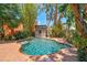 Private backyard retreat with a freeform pool, brick patio, and tropical landscaping at 506 S Melville Ave, Tampa, FL 33606