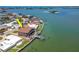 Aerial view of waterfront home with a private dock, balcony and luscious landscaping at 514 Harbor N Dr, Indian Rocks Beach, FL 33785