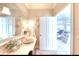 Bathroom featuring custom vanity with vessel sink, decorative mirror and lighting, and doorway to living area at 514 Harbor N Dr, Indian Rocks Beach, FL 33785