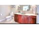 Bathroom boasting cherry wood vanity, a vessel sink, a decorative mirror, and white fixtures at 514 Harbor N Dr, Indian Rocks Beach, FL 33785
