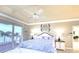 Main bedroom featuring balcony access with water views, a ceiling fan, and neutral decor at 514 Harbor N Dr, Indian Rocks Beach, FL 33785