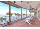 Covered waterfront patio with brick floors and white railings overlooking the water and dock at 514 Harbor N Dr, Indian Rocks Beach, FL 33785