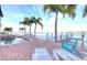 Beautiful waterfront pool with lounge chairs, palm trees, and a stunning view of the water at 514 Harbor N Dr, Indian Rocks Beach, FL 33785