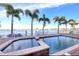 Inviting waterfront pool with integrated hot tub, surrounded by lush palm trees and stunning water views at 514 Harbor N Dr, Indian Rocks Beach, FL 33785