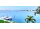 Serene view of the waterfront, featuring a private dock, boat lift, and clear blue waters at 514 Harbor N Dr, Indian Rocks Beach, FL 33785