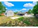 A full view of the backyard, featuring the house, a storage shed, and a concrete pad at 521 E Lumsden Rd, Brandon, FL 33511