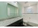 Clean bathroom featuring a vanity with marble countertop, a tub with shower, and light green walls at 521 E Lumsden Rd, Brandon, FL 33511