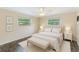 Bright bedroom featuring a ceiling fan, two windows, neutral walls, and a comfortable queen-sized bed with a bench at 521 E Lumsden Rd, Brandon, FL 33511