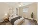 Bright bedroom featuring a ceiling fan, a window, neutral walls, a queen-sized bed, and artwork at 521 E Lumsden Rd, Brandon, FL 33511