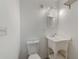 Simple half bath featuring a sink, mirror, and toilet at 521 E Lumsden Rd, Brandon, FL 33511