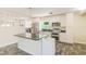 Modern kitchen featuring white cabinetry, stainless steel appliances, a granite countertop island, and tile flooring at 521 E Lumsden Rd, Brandon, FL 33511
