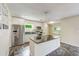 Well-lit kitchen with stainless steel appliances, white cabinets, a granite island, and tile flooring at 521 E Lumsden Rd, Brandon, FL 33511