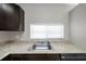 Kitchen sink area with granite countertops and dark wood cabinets at 5306 Marlwood Ct, Tampa, FL 33624