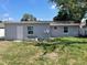 Backyard featuring a simple exterior with a white door and trimmed lawn and a small garden plot at 6102 Massachusetts Ave, New Port Richey, FL 34653