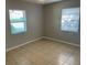 Cozy bedroom with tile flooring, two windows offering plenty of natural light at 6102 Massachusetts Ave, New Port Richey, FL 34653