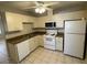 Functional kitchen featuring white appliances, a microwave, and ample cabinet space at 6102 Massachusetts Ave, New Port Richey, FL 34653