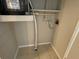 Small utility room with tile flooring and wall shelves for storage at 6102 Massachusetts Ave, New Port Richey, FL 34653